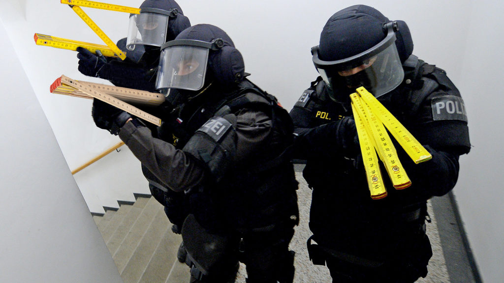 Polizisten mit Zollstöcken