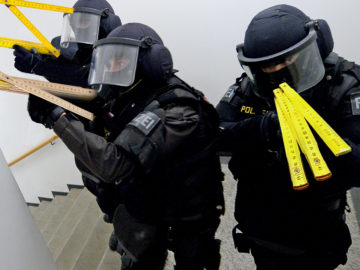 Polizisten mit Zollstöcken