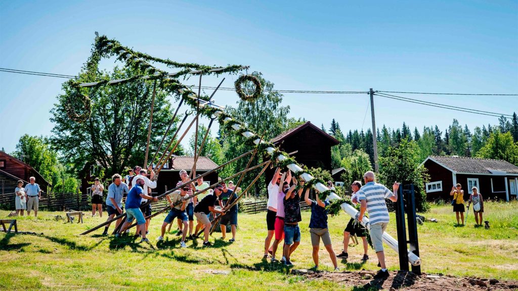 Menschen stellen Maibaum auf