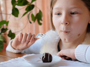 Mädchen isst begeistert Rumkugeln