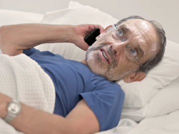 Faßmann telefonierend im Bett