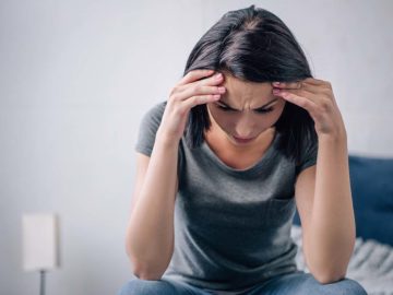 Frau weinend und genervt auf dem Bett