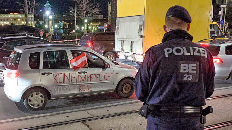 Polizist bewacht Corona Demo