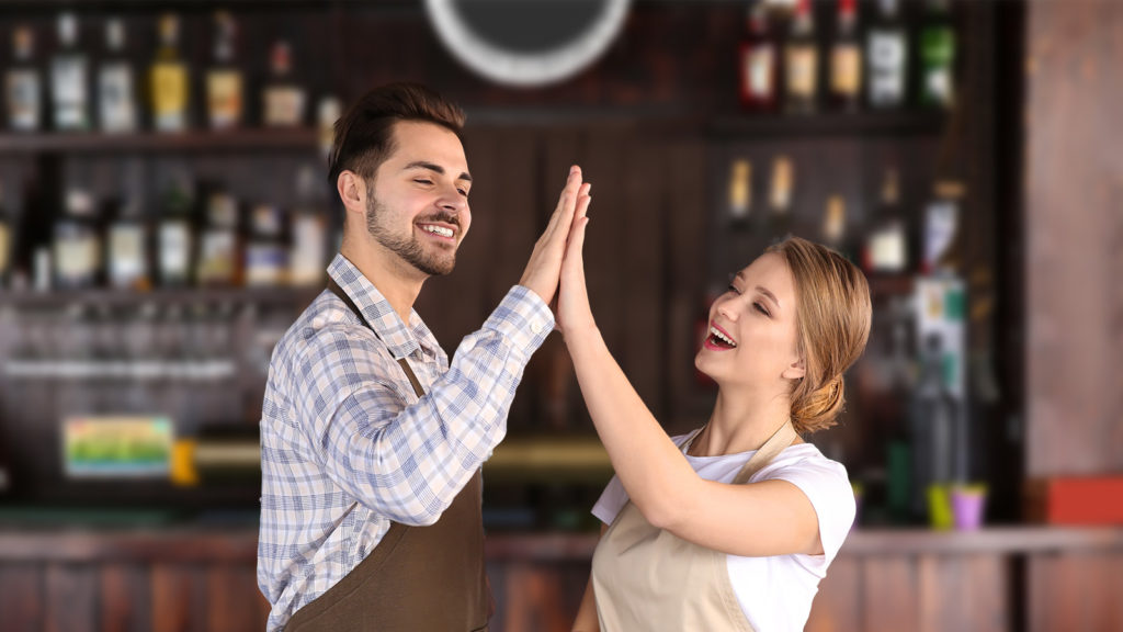 2 junge KellnerInnen geben sich ein High Five