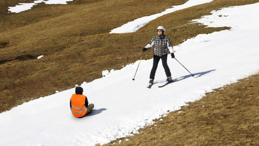 Ein Klimaaktivist blockiert eine 20 cm breite Schneepiste
