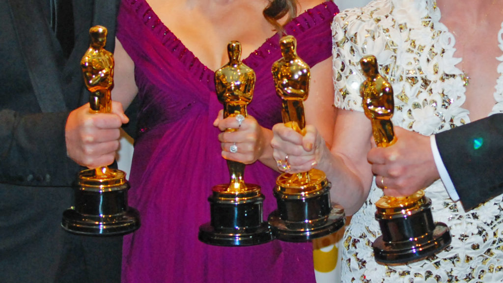Menschen halten Oscar-Awards in die Kamera