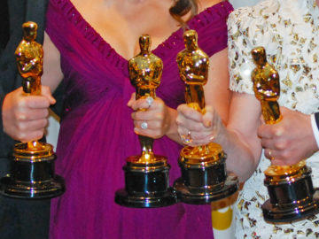Menschen halten Oscar-Awards in die Kamera
