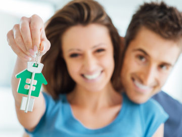 Ein verliebtes Paar mit Schlüsseln für ein Haus