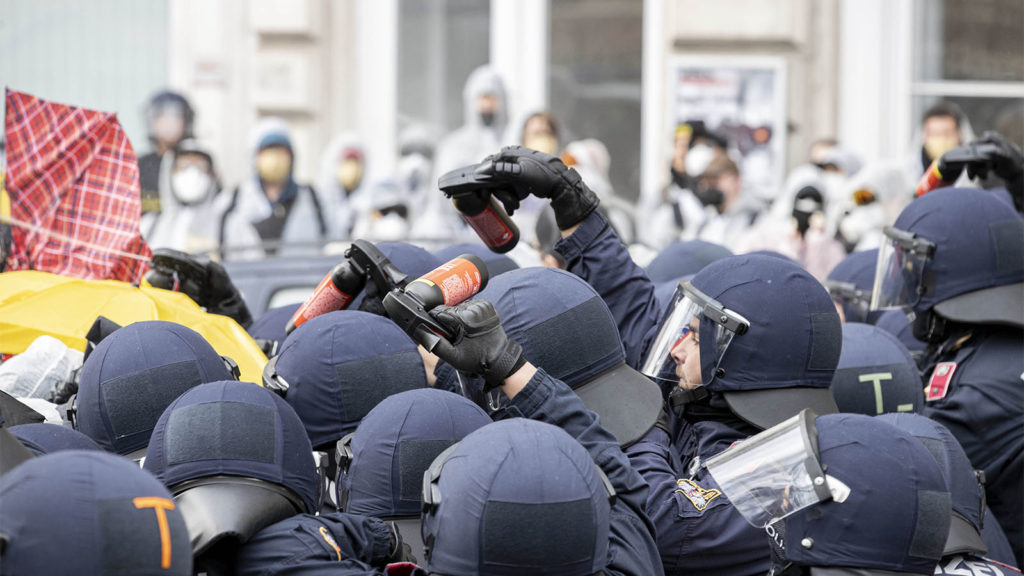 Polizisten mit Pfefferspraydosen