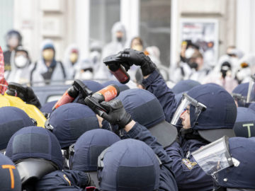 Polizisten mit Pfefferspraydosen
