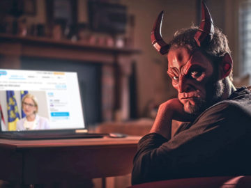 Satan sitzt vor Laptop mit Willhaben offen