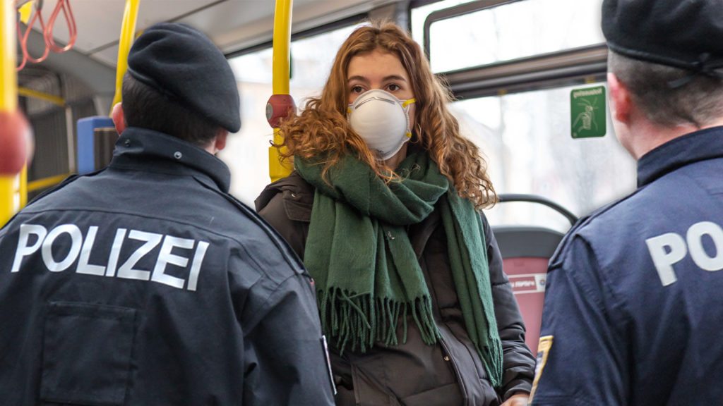 Zwei Polizisten konfrontieren junge Dame in Bus