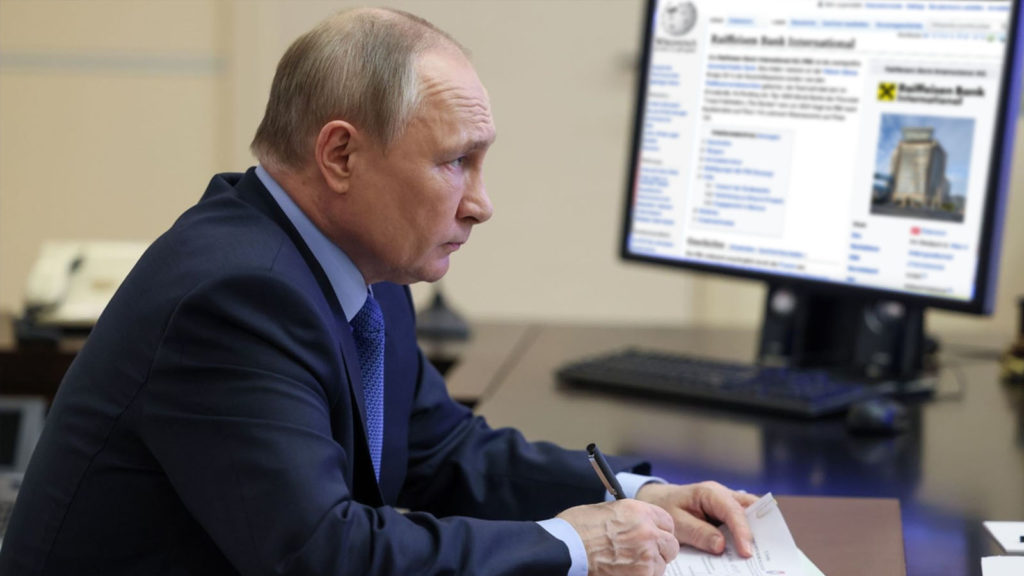 Putin schaut besorgt auf PC mit Raiffeisen Wikipedia-Eintrag