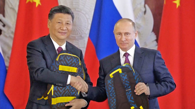 Xi und Putin halten einen Burton Rucksack und schütteln sich die Hände