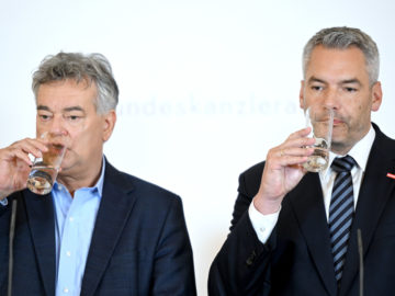 Kogler und Nehammer nehmen jeweils einen Schluck von einem Glas