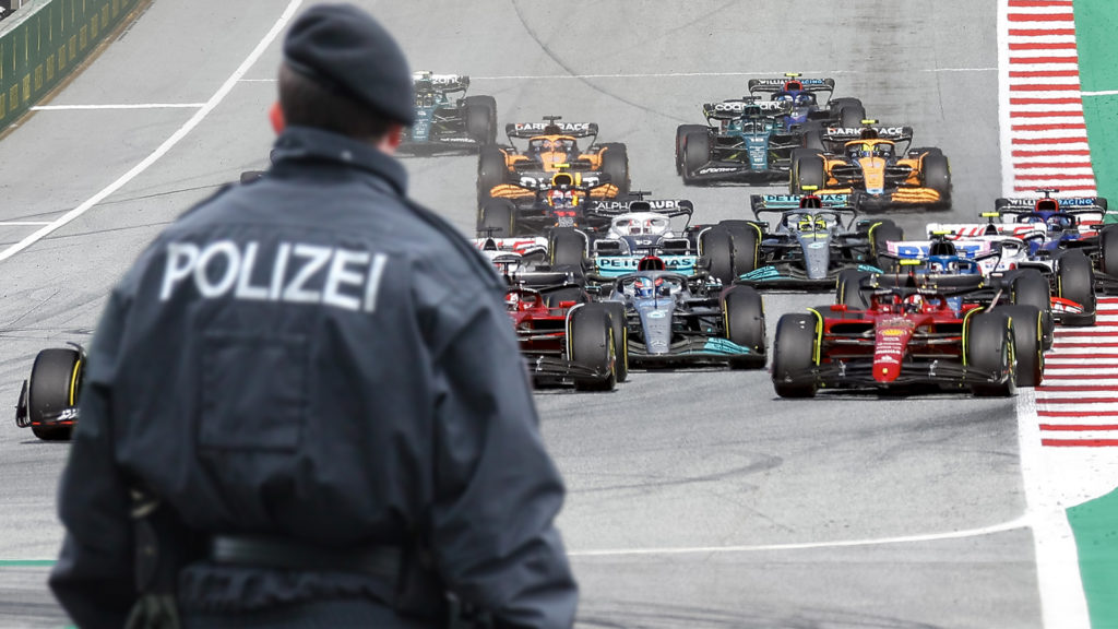 Polizist steht vor Formel 1 Autos