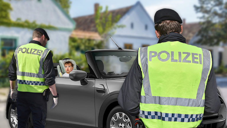 Zwei Polizisten warten vor einem Cabrio