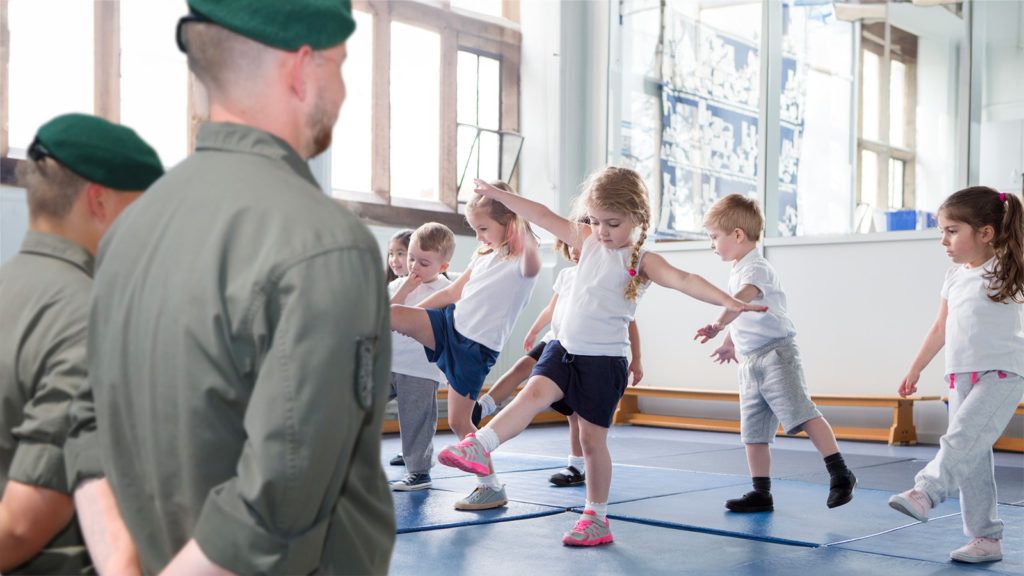 Soldaten beobachten Schüler beim Sportunterricht