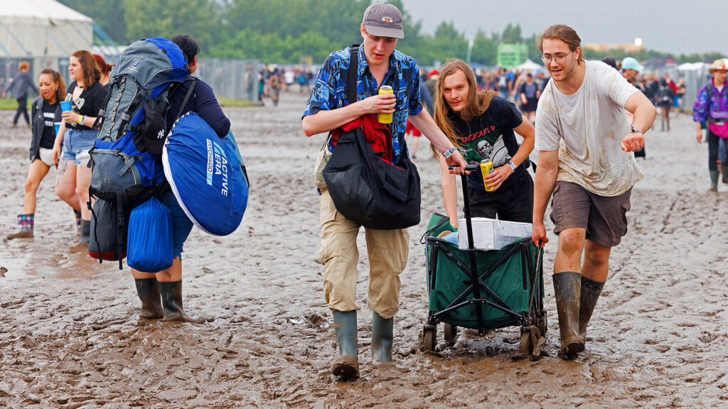 Nova-Rock-Besucher ziehen ein Wagerl durch den Schlamm