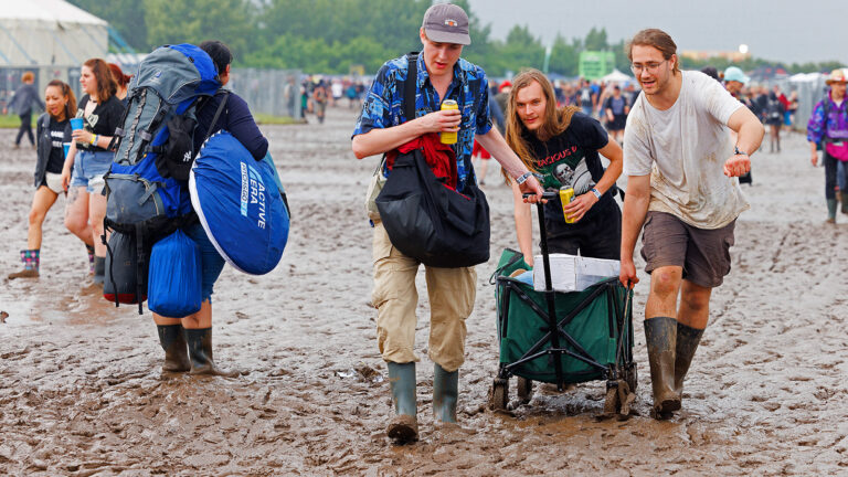 Nova-Rock-Besucher ziehen ein Wagerl durch den Schlamm