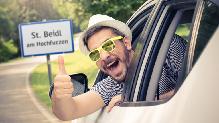 Mann im Auto zeigt den Daumen nach oben