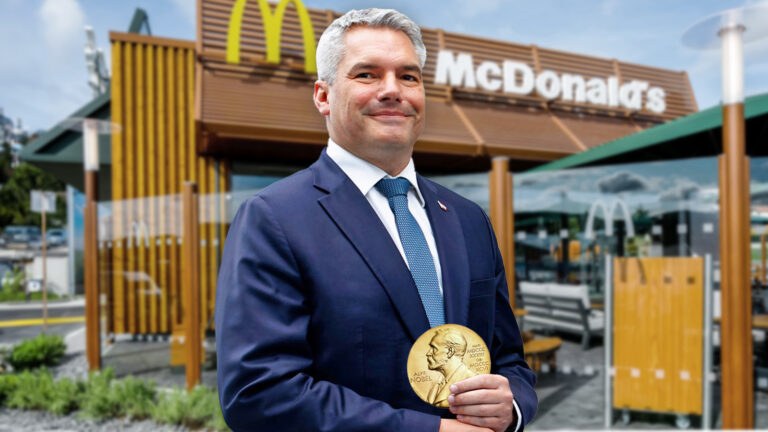 Nehammer vor einem McDonalds Restaurant. Er hält seinen Nobelpreise