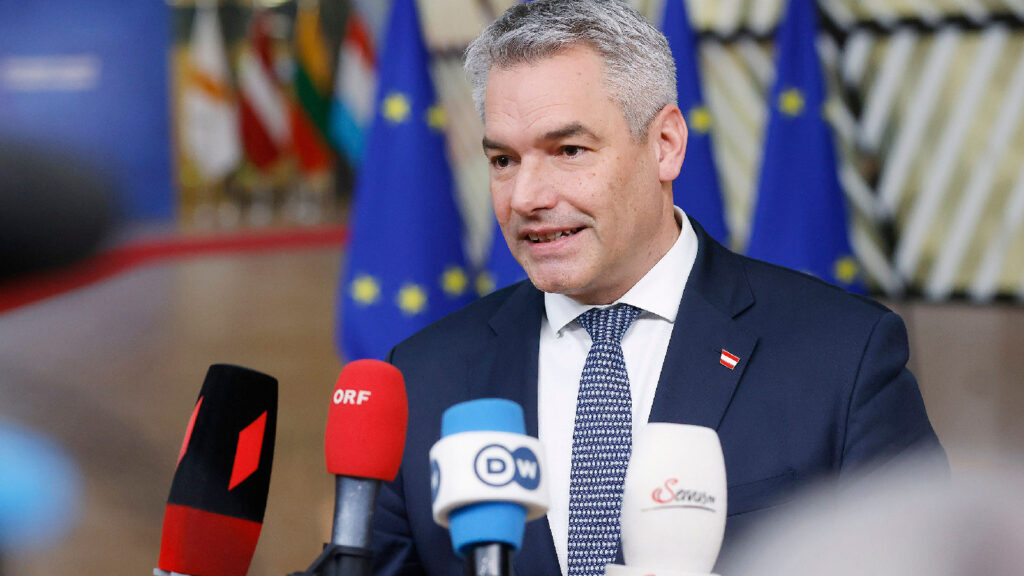 Nehammer vor Mikrofonen von Medienvertretern