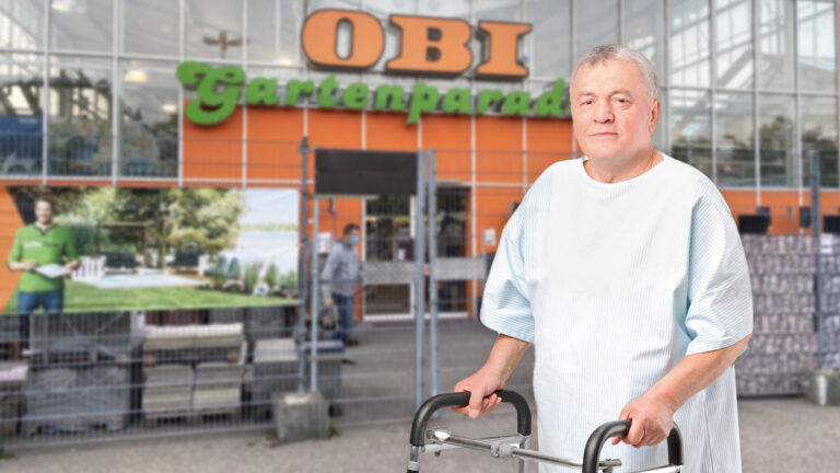 Ein Patient steht vor einem Obi Baumarkt