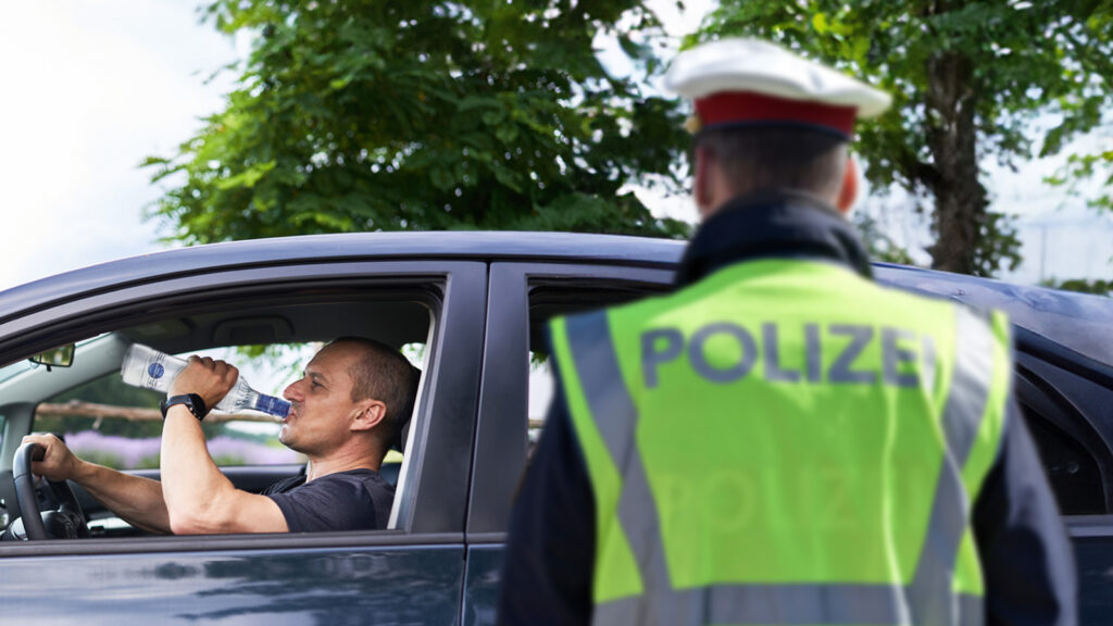 Ein Mann mit Vodka-Flasche in der Hand fährt aus einer Polizeikontrolle