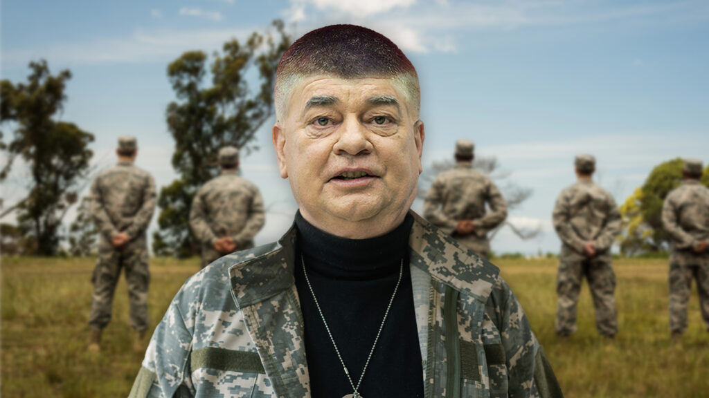 Werner Kogler steht im Camouflage-Outfit vor Soldaten