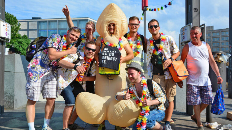 Ein Mann im Penis-Kostüm, neben ihm seine Freunde