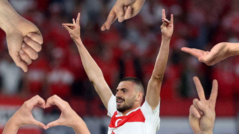 Demiral macht den Wolfsgruß, daneben viele Hände.