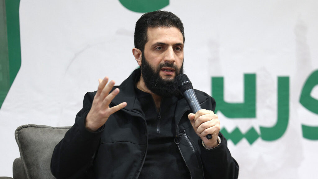 Syrischer Warlord hält ein Mikrofon.