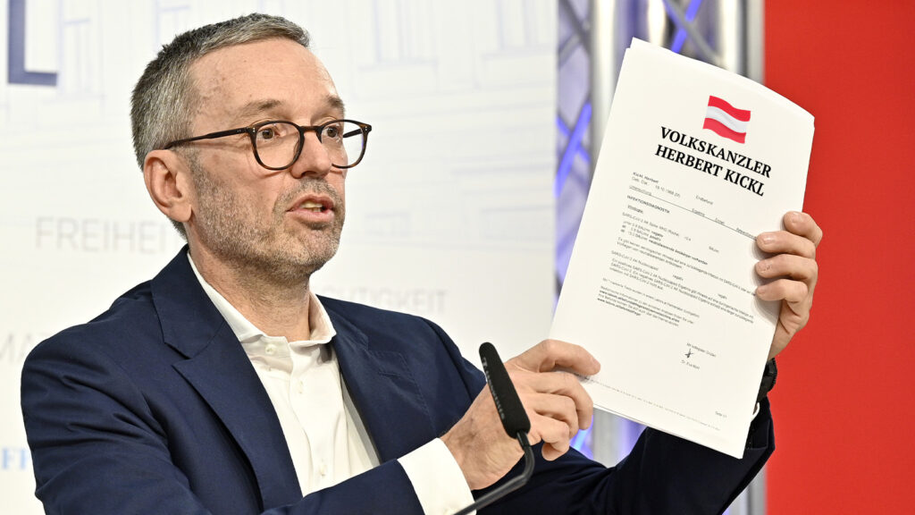 Das Bild zeigt Kickl mit einem Papier dass er in die Kamera hält.