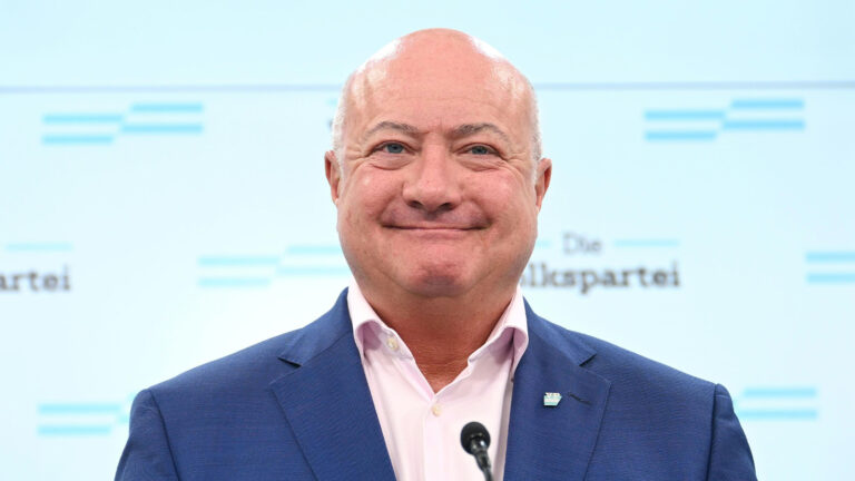 Das Bild zeigt einen selbstzufrieden lächelnden Christian Stocker.