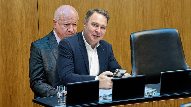 Das Bild zeigt Andreas Babler, der auf dem Schoß von Christian Stocker sitzt.