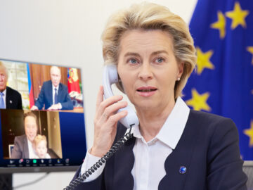 Das Bild zeigt Von der Leyen an einem Telefon. Im Hintergrund steht ein Bildschirm der Trump, Putin und Elon Musk zeigt.
