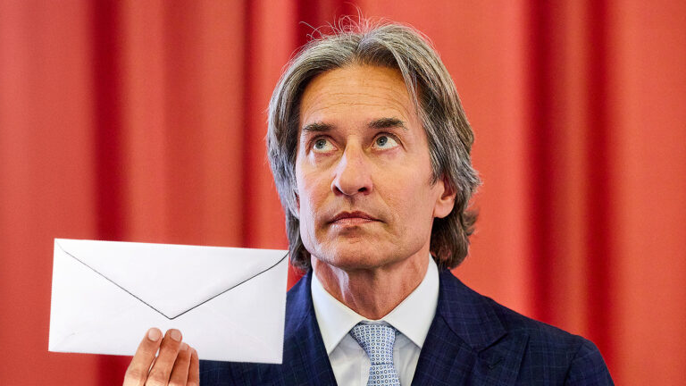 Das Bild zeigt Grasser mit einem Kuvert in der Hand.