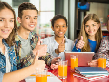 Das Bild zeigt eine Gruppe Schüler mit Gläsern Orangensaft.