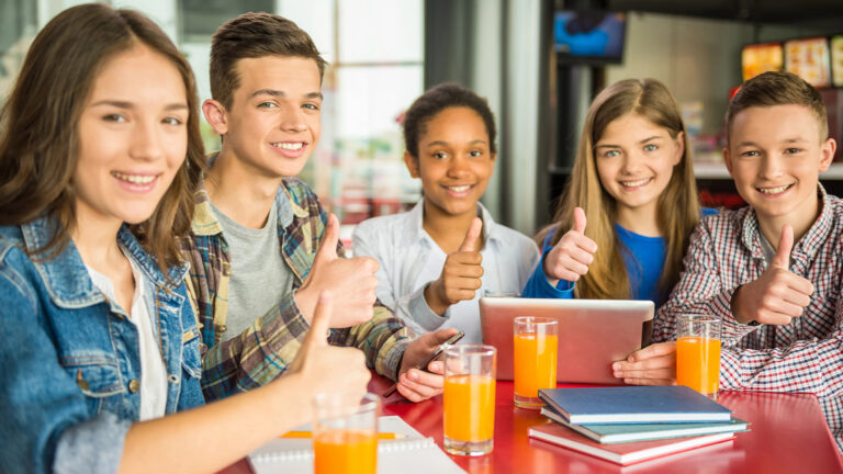 Das Bild zeigt eine Gruppe Schüler mit Gläsern Orangensaft.