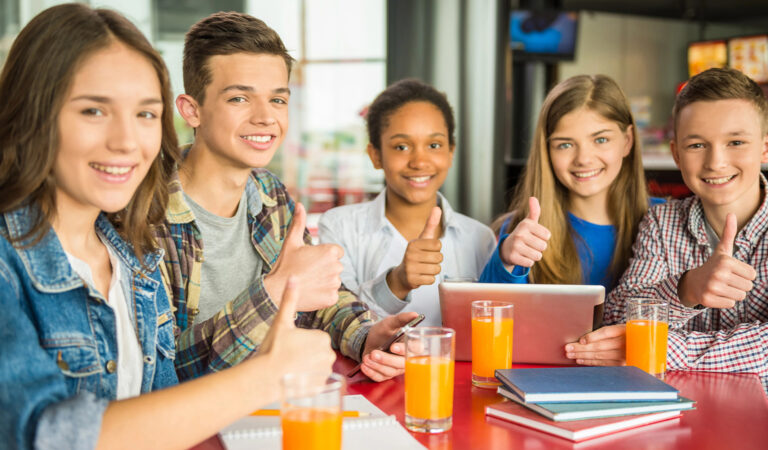 Das Bild zeigt eine Gruppe Schüler mit Gläsern Orangensaft.