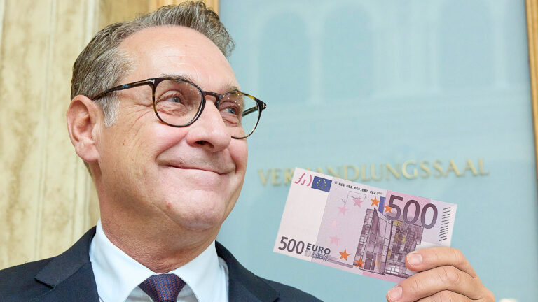 Das Bild zeigt Strache vor dem Verhandlungssaal mit einem 500€ Schein.