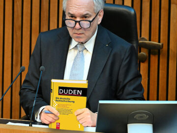 Das Bild zeigt Rosenkranz mit einem Duden in der Hand.