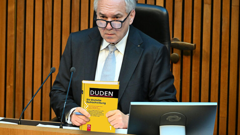 Das Bild zeigt Rosenkranz mit einem Duden in der Hand.