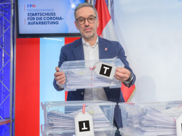 Das Bild zeigt Herbert Kickl mit Kisten voller Anfragen.