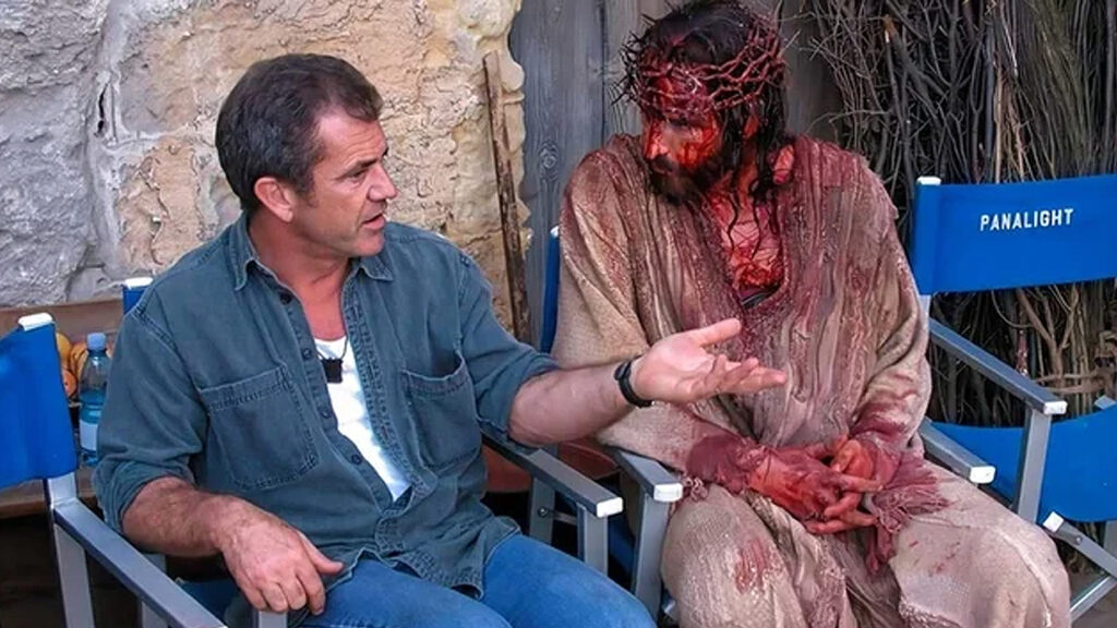 Das Bild zeigt Mel Gibson neben einem blutüberströmten Jesus-Darsteller.