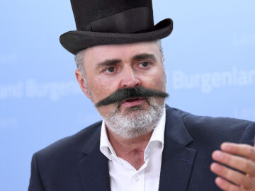 Das Bild zeigt Hans-Peter Doskozil mit einem Schnurrbart und Zylinder.