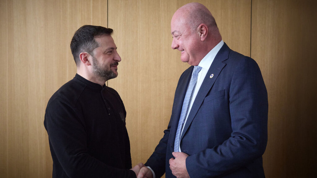 Das Bild zeigt Selenskyj und Stocker, wie sie sich die Hand geben.