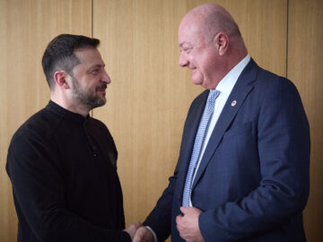 Das Bild zeigt Selenskyj und Stocker, wie sie sich die Hand geben.