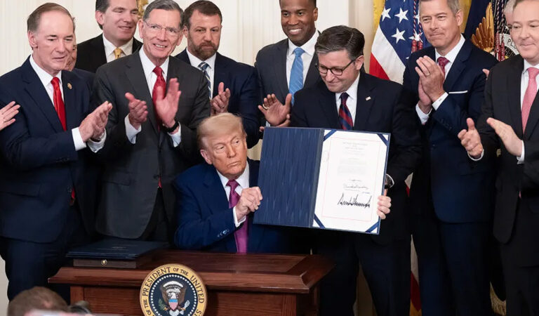 Das Bild zeigt Trump, umringt von Beratern, wie er seine Urkunde in die Kamera zeigt.